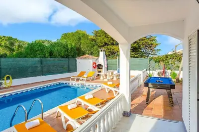 an outdoor swimming pool with chairs and a pool table at Villa Coelho in Albufeira