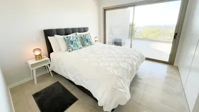 a bedroom with a white bed with a large window at Alvorada Premium by Sunny Deluxe in Albufeira