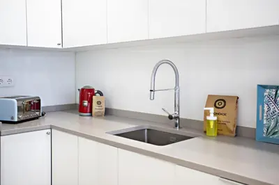 a kitchen with white cabinets and a sink at Casa da Vila in Faro