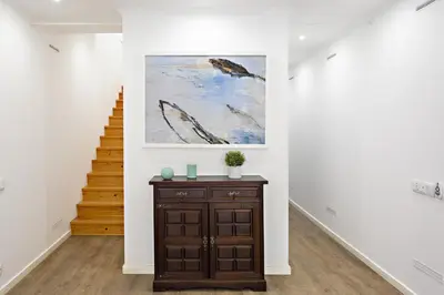 a hallway with a painting and a wooden cabinet at Casa da Vila in Faro