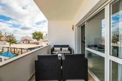 a balcony with two chairs and a view of a building at Casa Santa Maria - Sea View - 500m from the Beach - WiFi in Albufeira