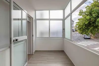 an empty room with large windows and a plant at Casa Santa Maria - Sea View - 500m from the Beach - WiFi in Albufeira