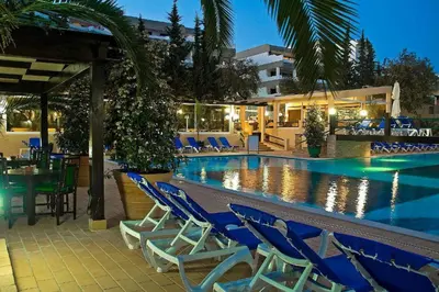 a swimming pool with blue chairs and a hotel at Apartamento Patrick by Sunnyway in Albufeira