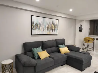 a living room with a gray couch with yellow pillows at Faro Main Avenue Apartment in Faro