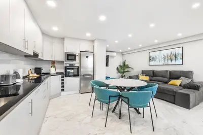 a kitchen and living room with a table and chairs at Faro Main Avenue Apartment in Faro