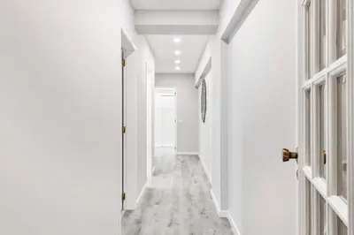 a hallway with white walls and a white door at Faro Main Avenue Apartment in Faro
