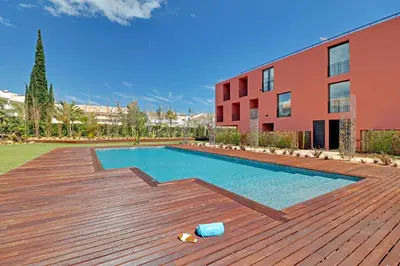 a swimming pool on a wooden deck next to a building at Dubai Apartment in Vilamoura