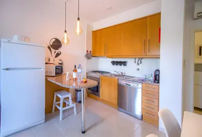 a kitchen with wooden cabinets and a white refrigerator at ALFELI-AP in Olhos de Água