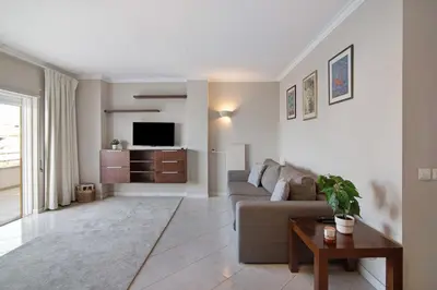 a living room with a couch and a tv at Vilamoura Apartment 3 bedroom in Vilamoura