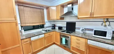 a kitchen with wooden cabinets and a stove top oven at Sweet Garden by SpotOn Apartments in Albufeira