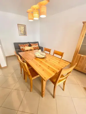 a wooden dining room table with chairs and a couch at Sweet Garden by SpotOn Apartments in Albufeira