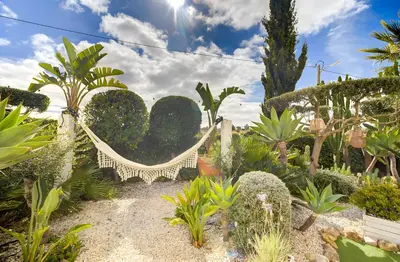 a swing in a garden with plants and trees at Vila Rafa in Albufeira