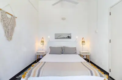 a white bedroom with a bed and two lamps at Vila Rafa in Albufeira