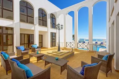 a living room with chairs and tables and a balcony at Villa Albuar in Patroves