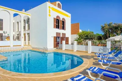a swimming pool with chairs and a building at Villa Albuar in Patroves