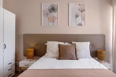a bedroom with a bed with two night stands and three pictures at Casa Maria in Faro