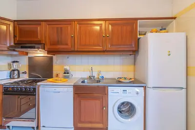 a kitchen with a white refrigerator and a dishwasher at Albufeira Salgados Beach 2 by Homing in Albufeira
