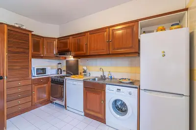 a kitchen with a white refrigerator and a dishwasher at Albufeira Salgados Beach 2 by Homing in Albufeira