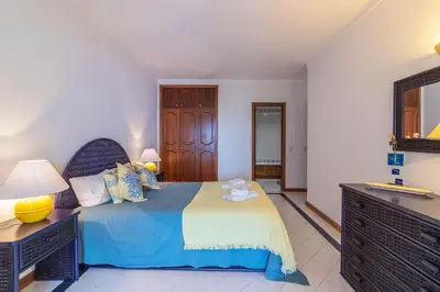 a bedroom with a bed with a blue and white blanket at Albufeira Salgados Beach 2 by Homing in Albufeira
