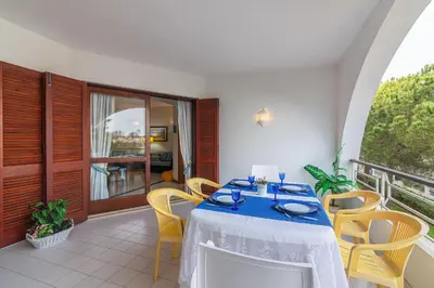 a dining room with a table and chairs on a balcony at Albufeira Salgados Beach 2 by Homing in Albufeira