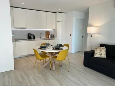 a living room with a table and chairs and a couch at Terraços Quarteira 2D3 in Quarteira