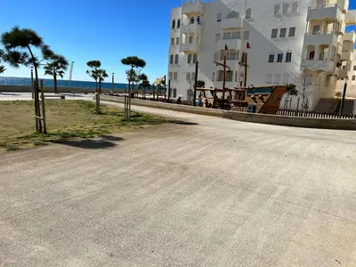 an empty street next to a building and a beach at Terraços Quarteira 2D3 in Quarteira