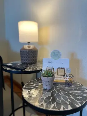 a living room with a black couch and two tables at Title e Title - Oura Apartament Albufeira in Albufeira