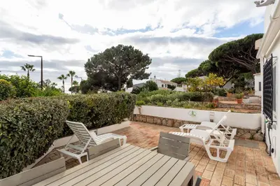 a patio with two white chairs and a wooden deck at Townhouse Seraphina in Vale do Lobo