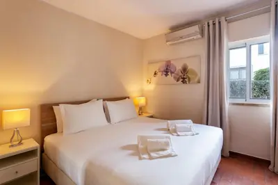 a bedroom with a large white bed and a window at Townhouse Seraphina in Vale do Lobo