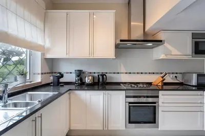 a kitchen with white cabinets and a sink at Townhouse Seraphina in Vale do Lobo
