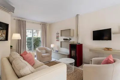 a living room with a couch and two chairs and a tv at Townhouse Seraphina in Vale do Lobo
