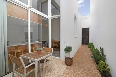 a patio with a table and chairs in a house at Casa Vermelha ii in Faro