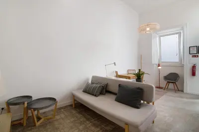 a living room with a couch and a table and chairs at Casa Vermelha ii in Faro