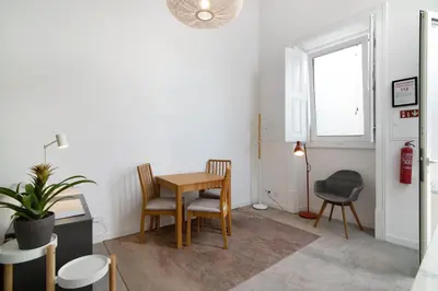 a dining room with a table and chairs and a window at Casa Vermelha ii in Faro