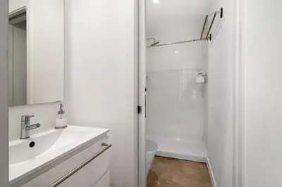 a white bathroom with a sink and a lamp at Casa Vermelha ii in Faro