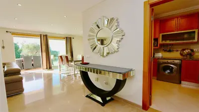 a living room with a table and a mirror on the wall at Villa Terraços da Vinha 230 - Clever Details in Vilamoura
