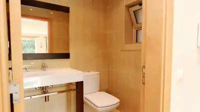 a bathroom with a toilet and a sink and a mirror at Villa Terraços da Vinha 230 - Clever Details in Vilamoura