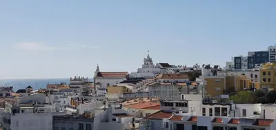 a group of buildings on a hill near the ocean at Apartamento Dionisio in Albufeira