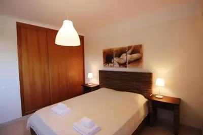 a bedroom with a bed and a painting on the wall at Lago Azul Apartment II in Quarteira