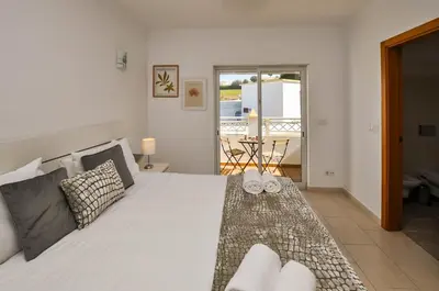 a bedroom with a large white bed with two towels on it at Albufeira Townhouses by OCvillas in Albufeira