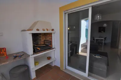 a table with chairs and an umbrella on a balcony at Albufeira Townhouses by OCvillas in Albufeira