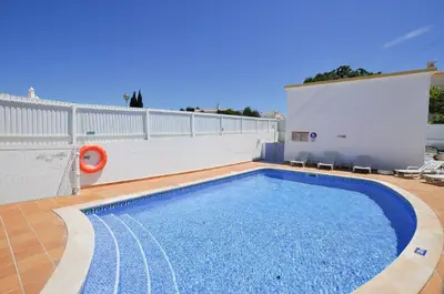 a swimming pool on the side of a house at Albufeira Townhouses by OCvillas in Albufeira