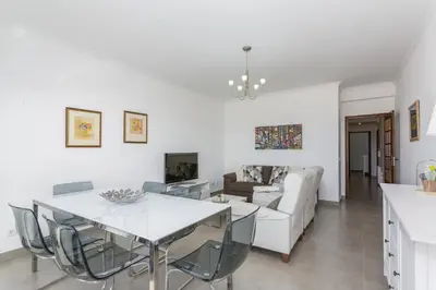 a white living room with a white table and chairs at Miral 3 - Sea front by HD PROPERTIES in Quarteira