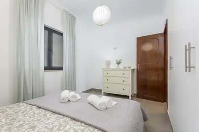 a white bedroom with two towels on a bed at Miral 3 - Sea front by HD PROPERTIES in Quarteira