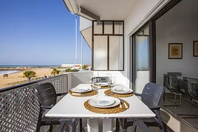 a white table with chairs and a view of the beach at Miral 3 - Sea front by HD PROPERTIES in Quarteira