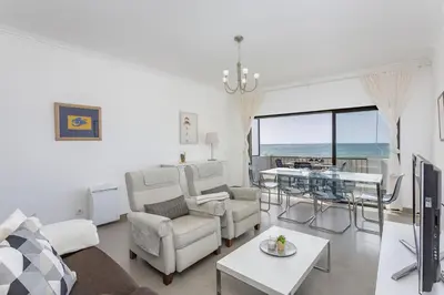 a living room with white furniture and a view of the ocean at Miral 3 - Sea front by HD PROPERTIES in Quarteira