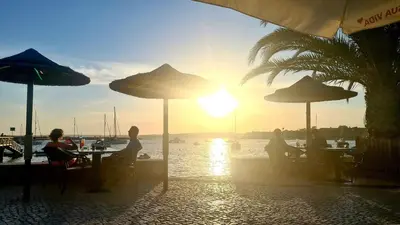 a group of people sitting at tables with umbrellas at Albufeira Balaia Mar e Sol in Albufeira