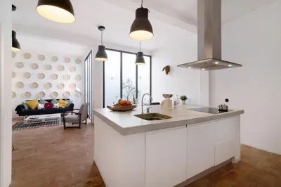 a kitchen with white cabinets and a table and chairs at Casa Loulé in Loulé
