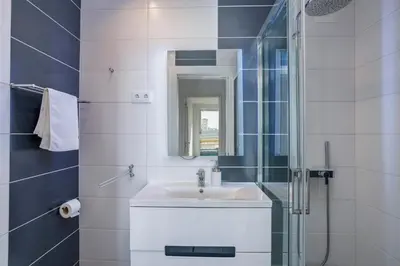 a white bathroom with a sink and a mirror at Old Town Beach Apartments in Albufeira