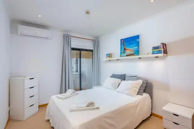 a bedroom with a white bed and a window at Old Town Beach Apartments in Albufeira